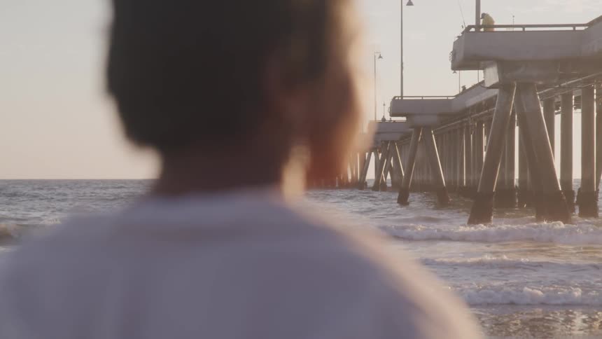 A portrait of a man contemplatively thinking near the beach