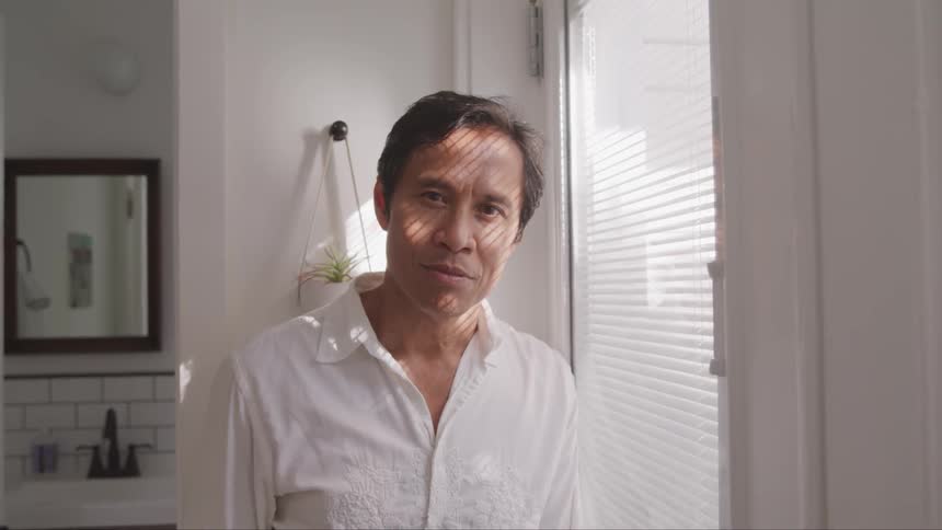 A portrait of a middle age man in the white room