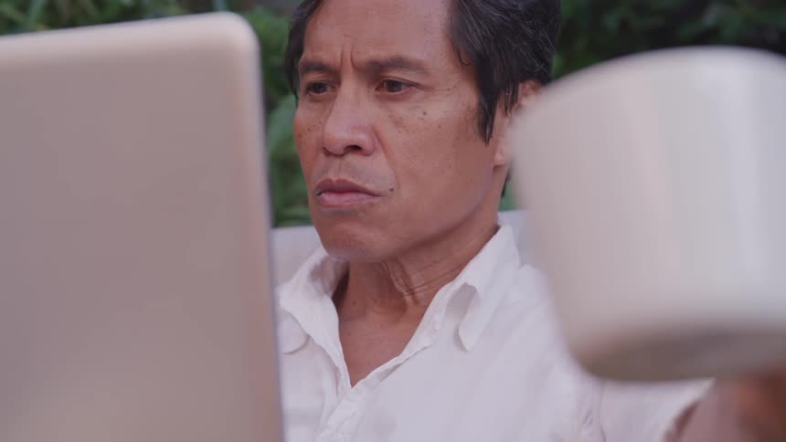 A man working on his laptop with a cup of coffee