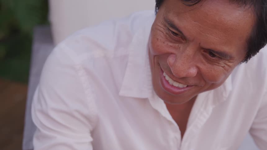 Man in a white shirt smiles