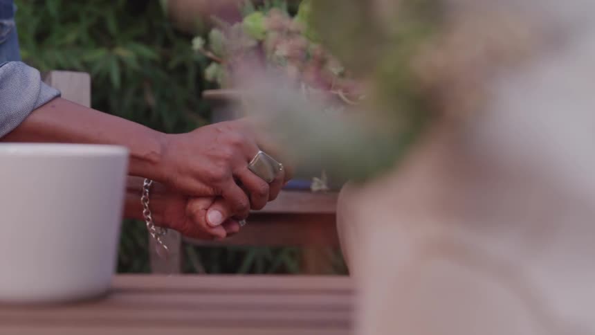 A woman grasps a mans hand in both of hers