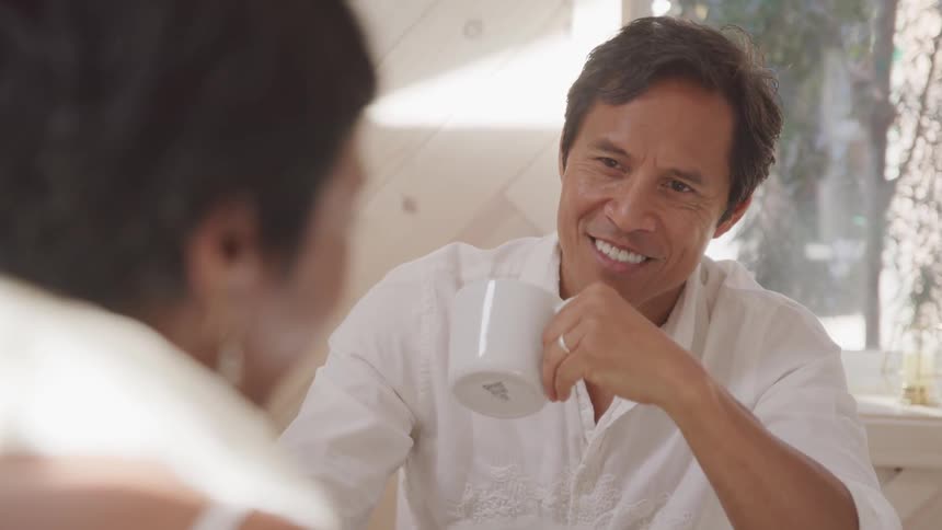 Husband and wife are smiling together indoors