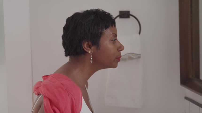 A woman stares into a mirror