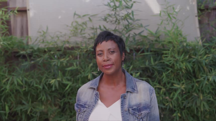 A black woman raising her head to look into the camera