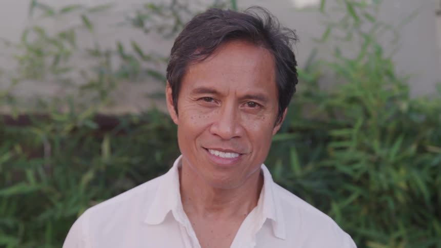 A man is blinking and smiling