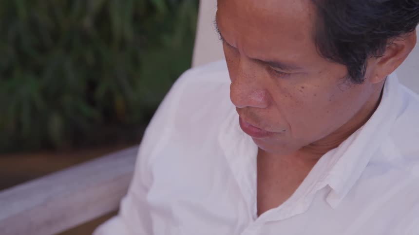 Close up of man sitting on chair outdoors