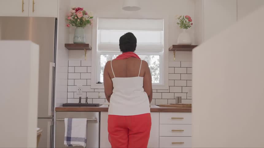 A woman cleaning the dish at the kitchen
