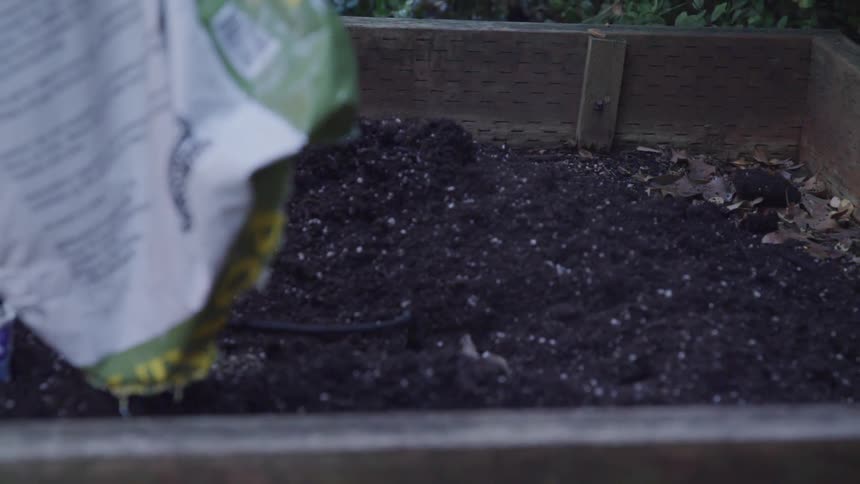 Man pouring soil into the plant box