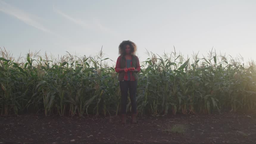 A woman is standing in front of a farm
