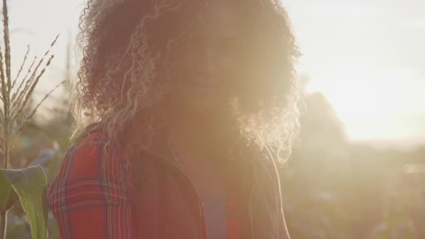A footage of a blonde black woman on the corn field