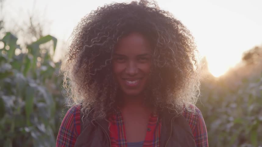 A black woman raising her head to smile at the camera