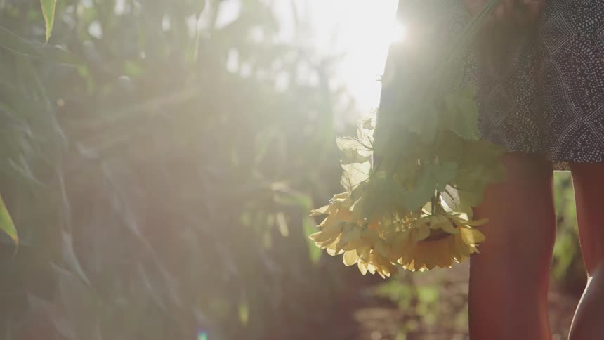 A girl holds a bunch of daisies while standing outside