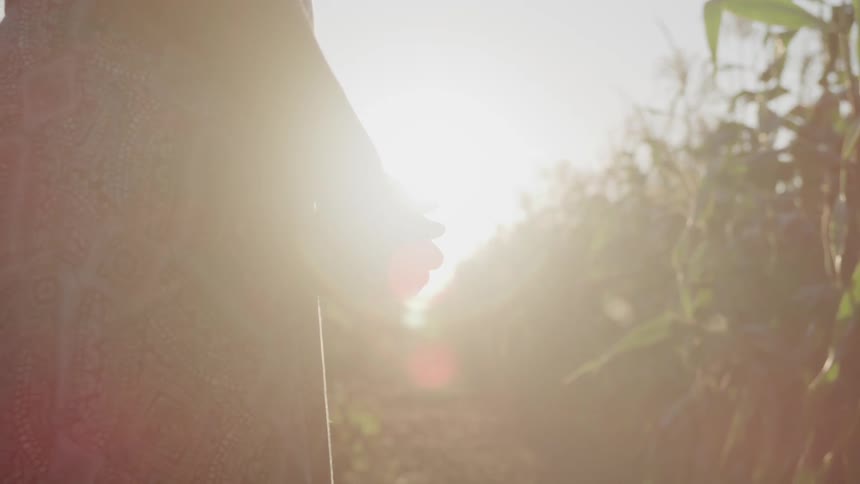 A woman is holding her hands together and standing by produce