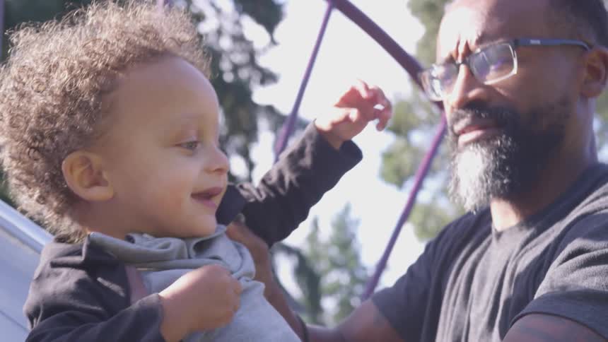 A black man play with his toddler