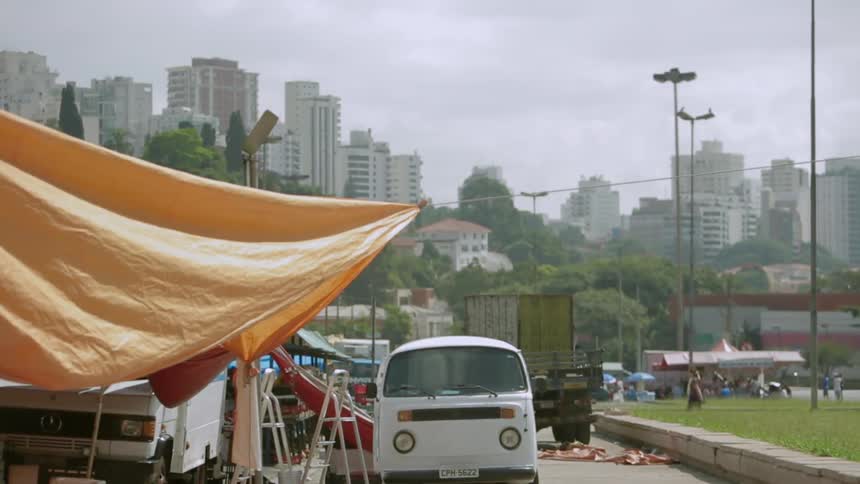 Van and truck parked next to a canopy in a city