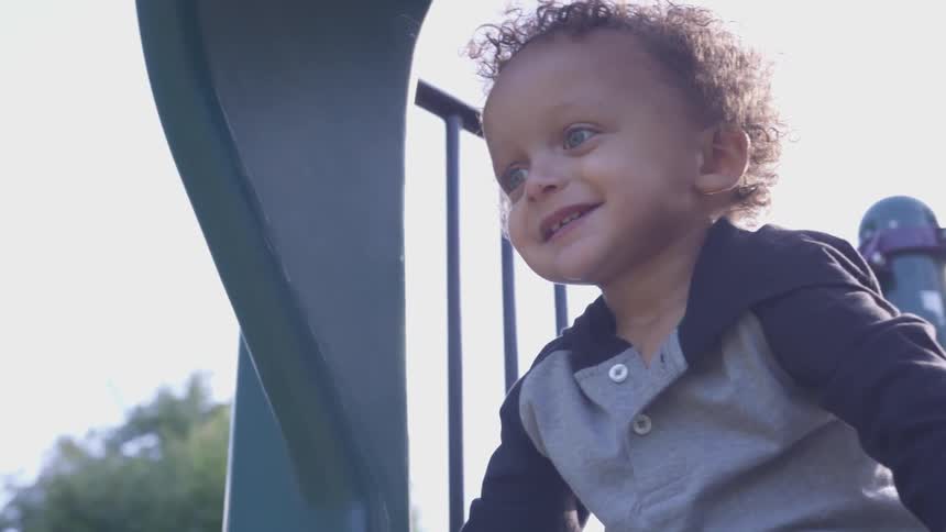 Toddler climbs on playground equipment