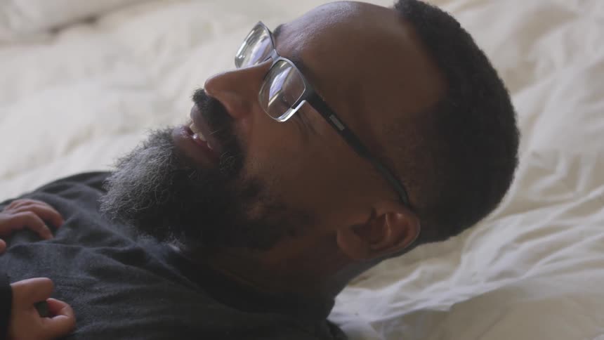 A man lies in bed with his child