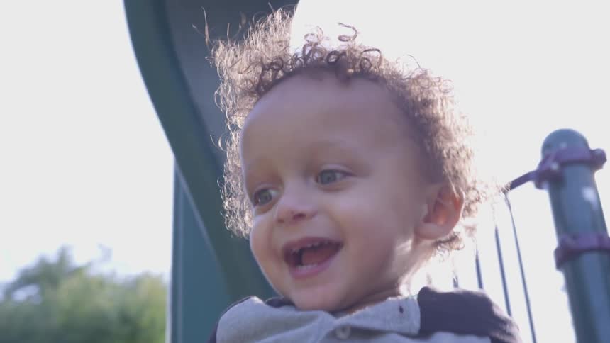 A young boy goes down a park slide