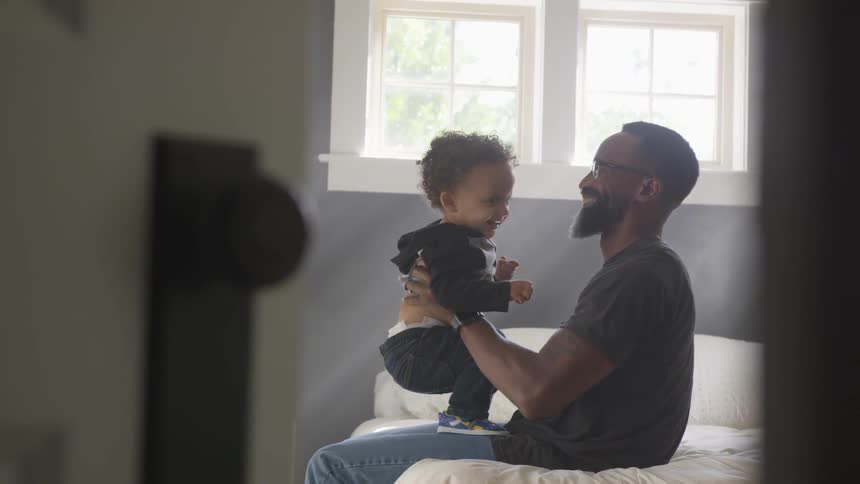 Father and son playing in the bedroom