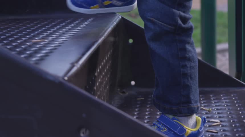 A child walks slowly up the steps