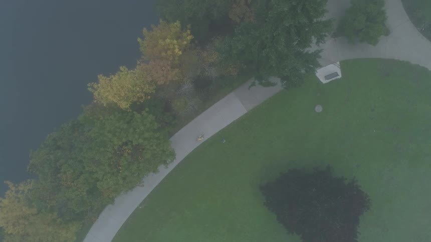 Man rides a bike along the bicycle road next to the lake in the park
