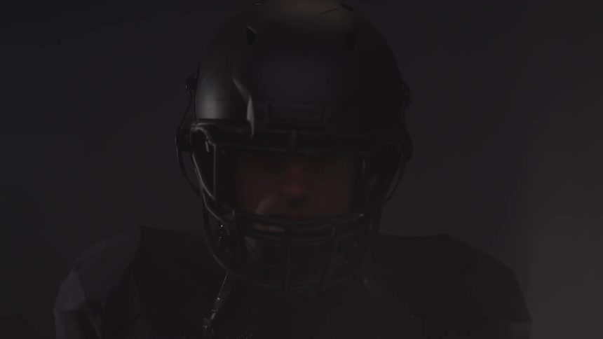 A man wearing a football helmet is lifting his head up