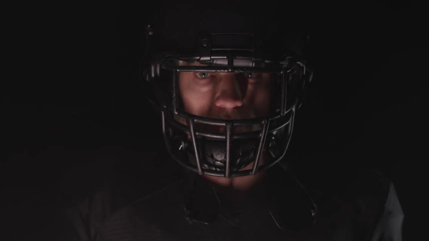 Man stands staring while wearing football uniform