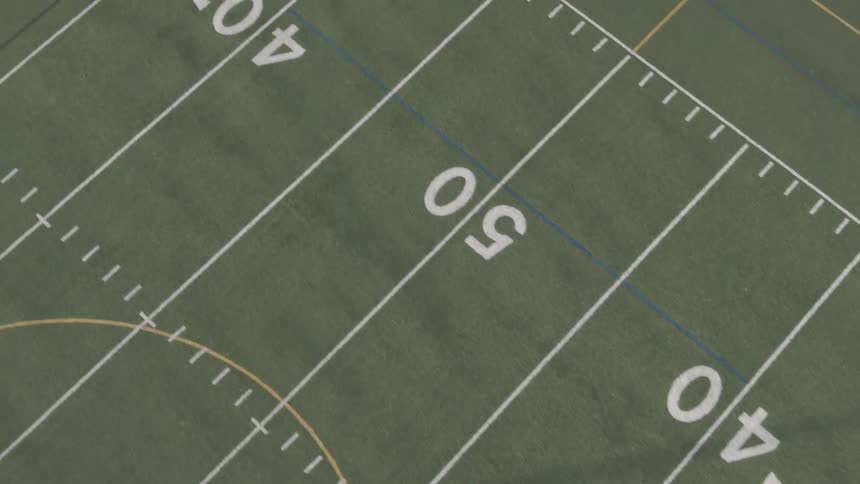 Yard markers in white on the turf of a football field