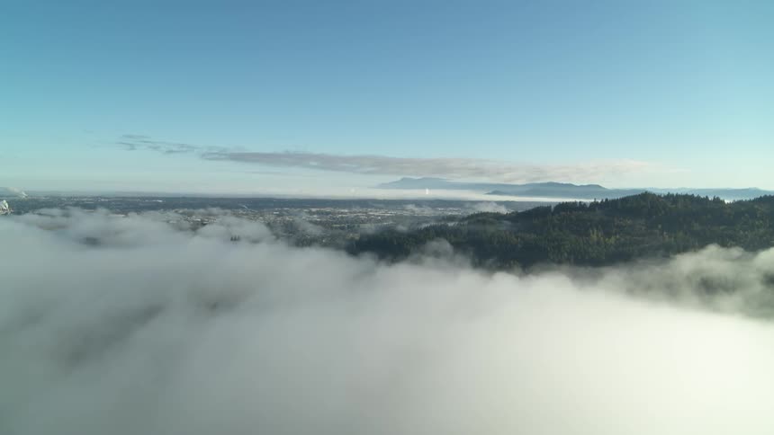 The clouds roll over the mountains by the city