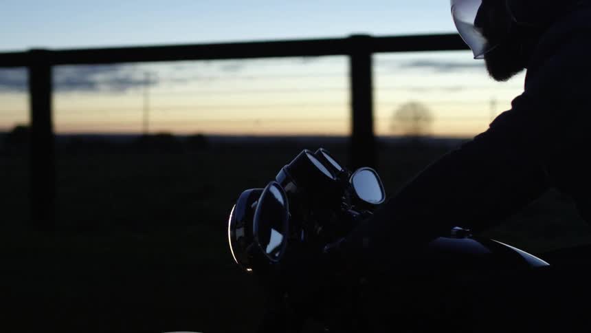 A person on a motorcycle drives down a road