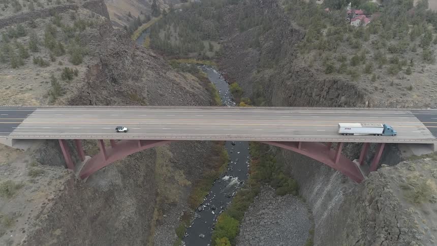 Vehicles travel over the bridge high above the river
