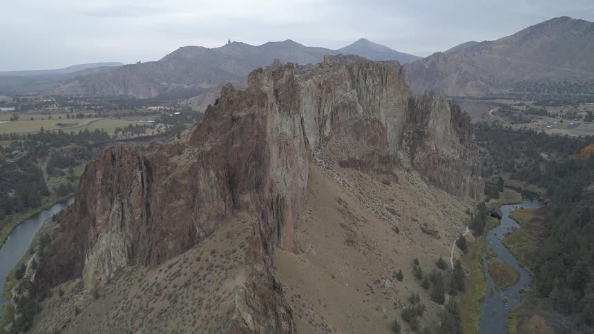 A river running around a mountain lined with walking paths