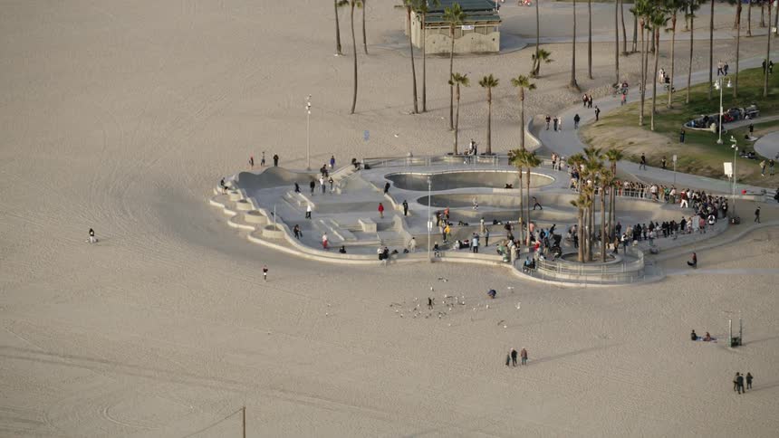 Skateboarders skate at a skatepark on the beach