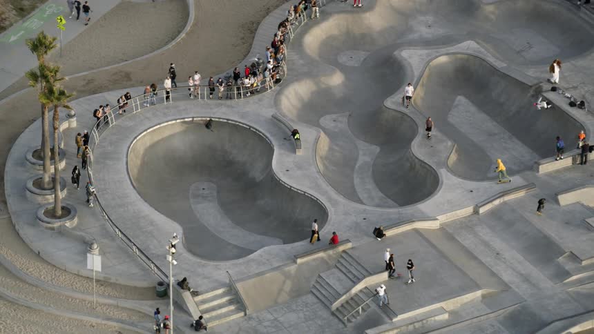 Spectators and skateboarders occupy skateboard park
