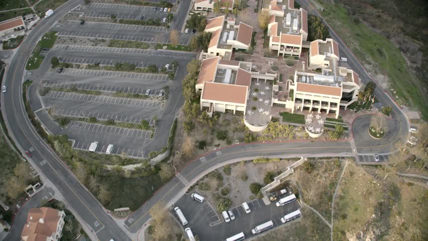 An urban area with several buildings sprawls near a long slope