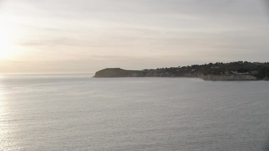 A headland reaching out into the ocean on a cloudy evening