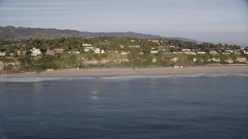 Numerous luxurious homes line a gorgeous beach covered coastline