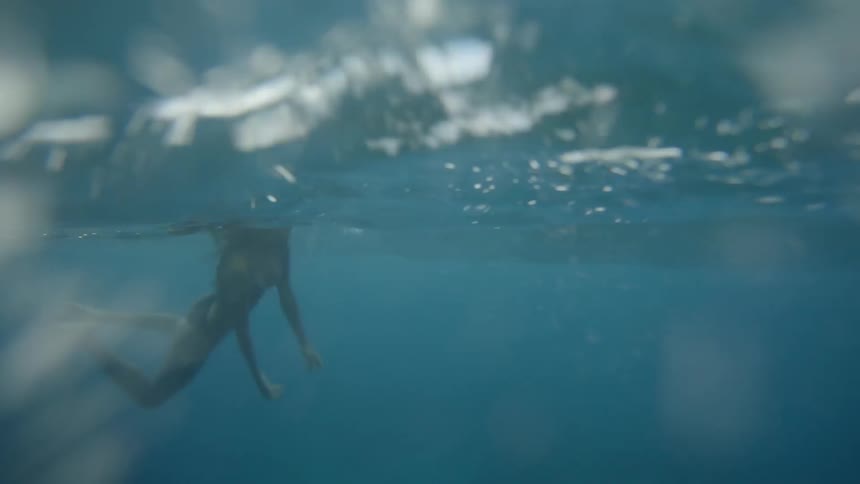 An underwater footage of woman swim at the sea