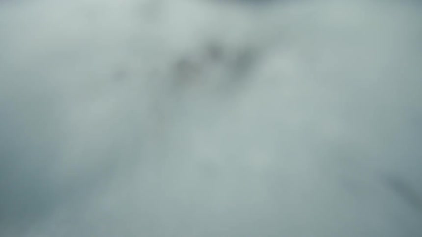 A woman jumps off a cliff and into the clear tropical water