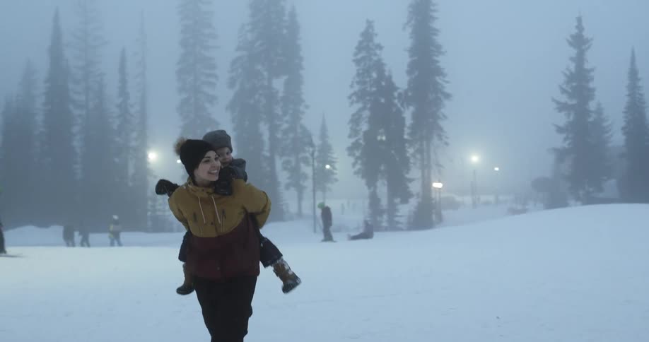 Mother piggy backing her son on the snow