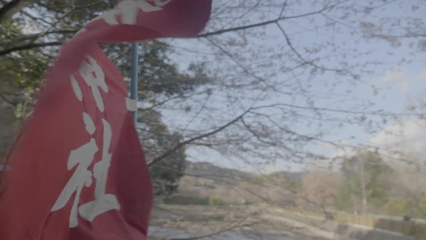 A red flag with chinese test flows in the wind next to a walkway