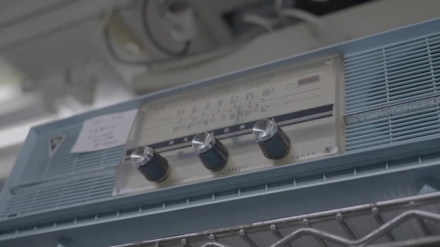 A medium wave radio on a shelf with a note on it