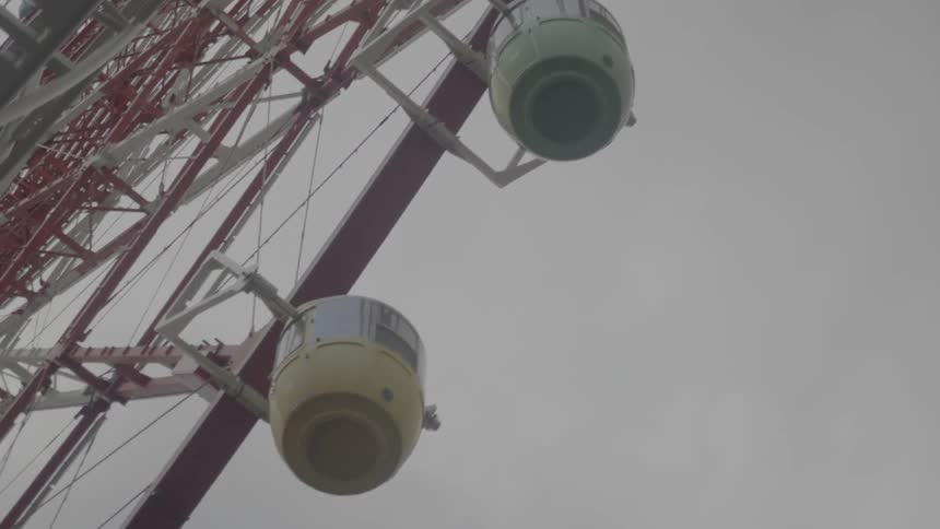 Differently colored passenger cars on a ferris wheel