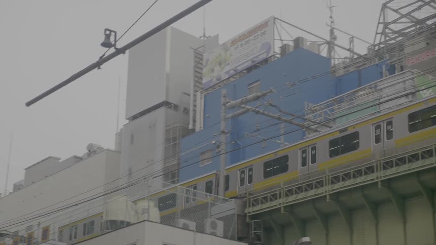 Light rail passes over head past buildings