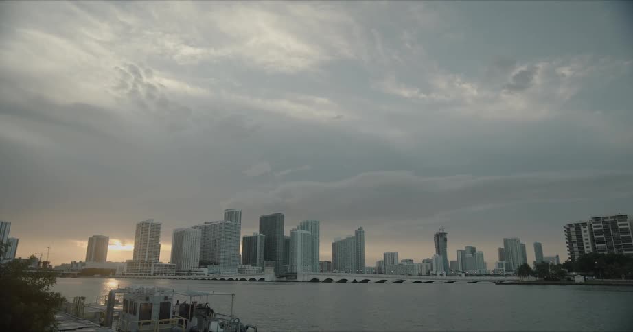 Skyline of the city with tall buildings and skyscrapers next to the sea at sunset