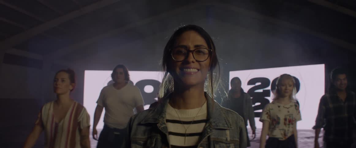People go towards the camera and one woman smiles directly into it