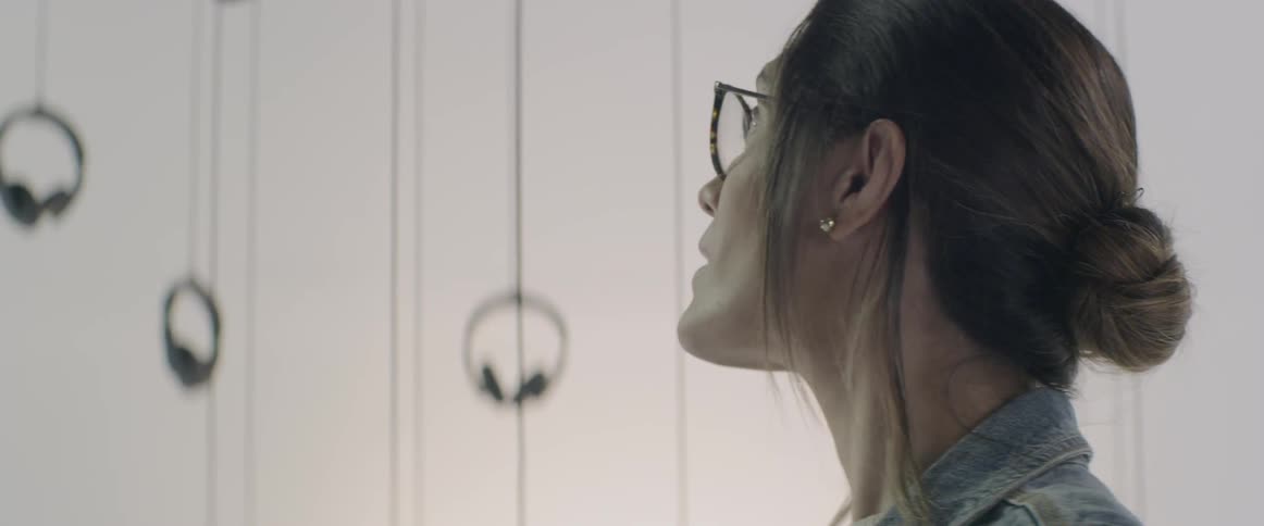 A woman wearing glasses is looking around a room