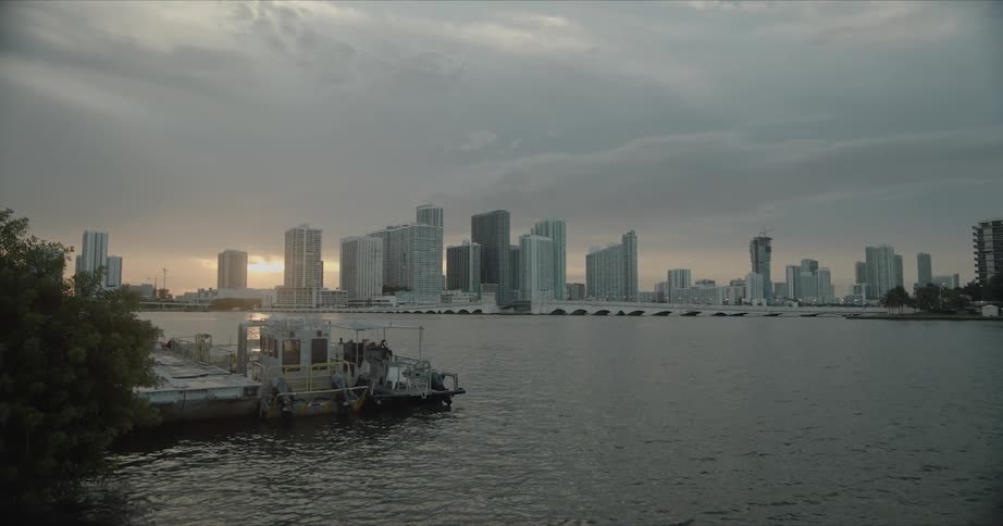 Skyline of the city with tall buildings and skyscrapers next to the sea at sunset