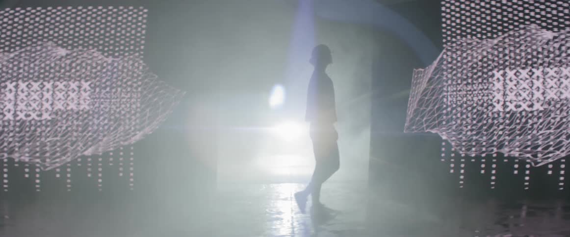 A woman walks toward the camera coming from the backstage