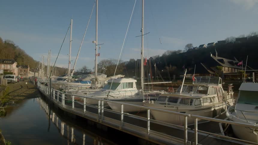 Cars parked near marina overlooked by houses on a hill
